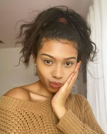 Sierra Capri in a brown sweater poses for a selfie.